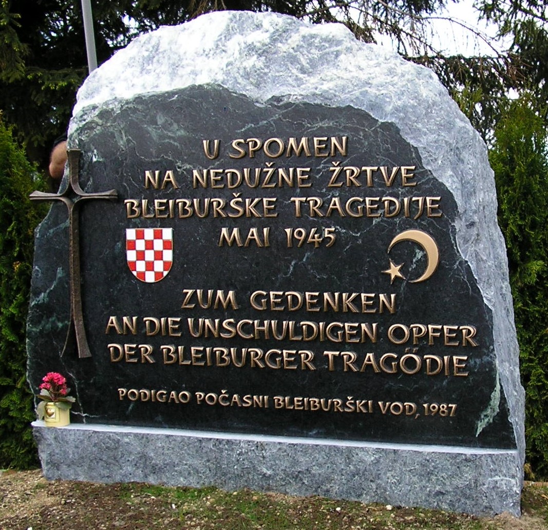 Spomen-kamen na Bleiburškom polju s hrvatskim grbom i natpisom „U spomen na nedužne žrtve bleiburške tragedije, svibanj 1945.“